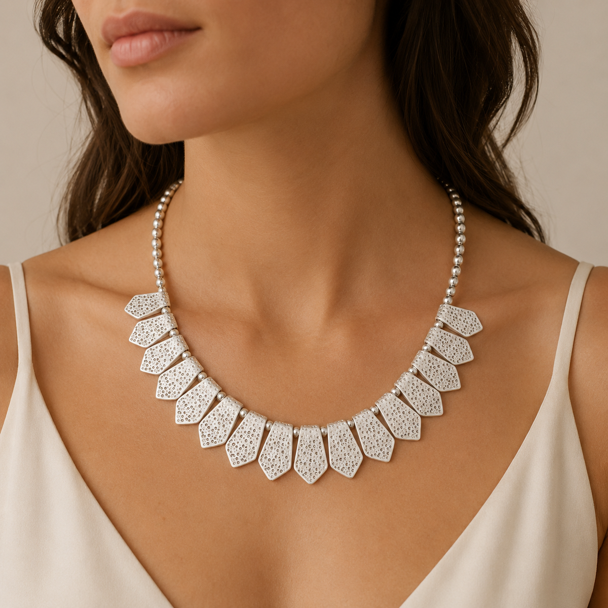 Silver-tone bib necklace shown from the front on a white background.
