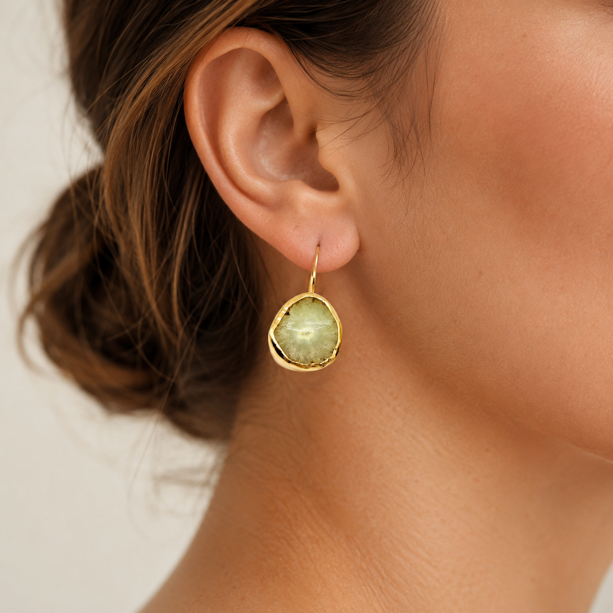 Raw garnet hoop earrings shown from the front with gold-plated edges.