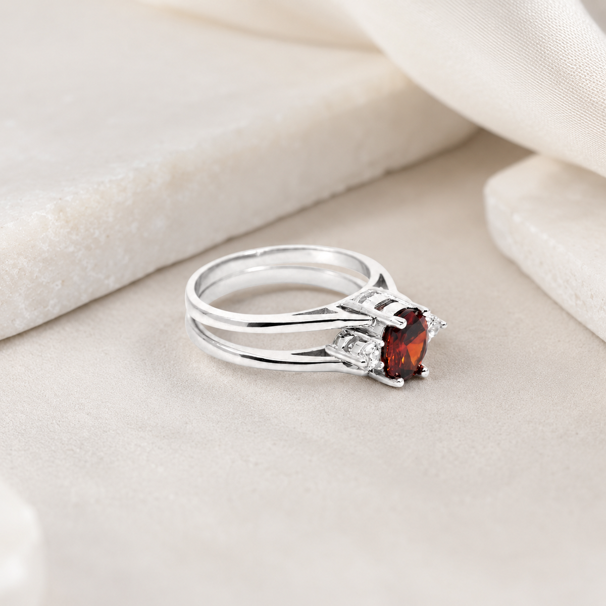 A ruby stone ring with a sleek silver-tone double band silhouette.