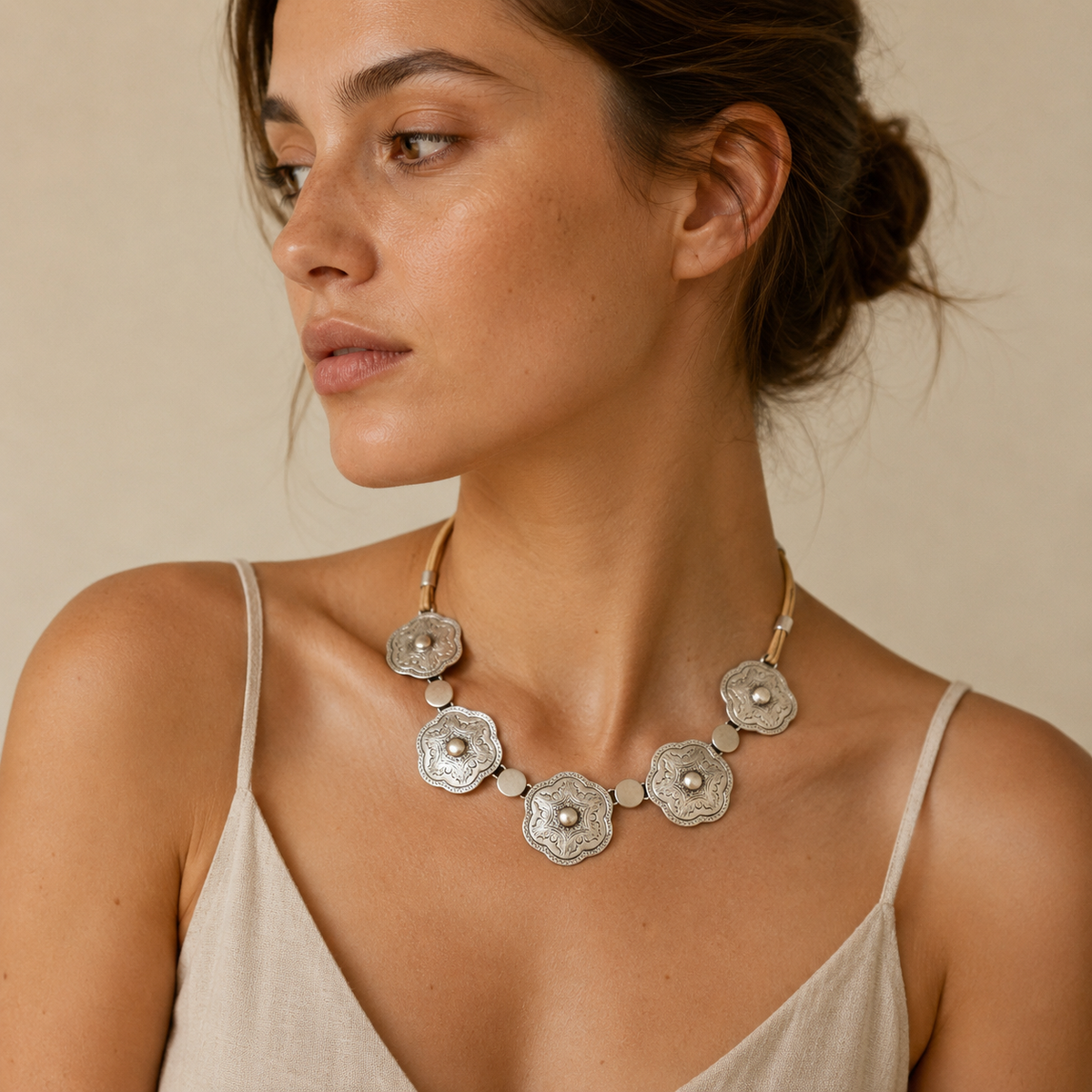Silver-tone floral plate necklace with etched detailing and round connector accents.