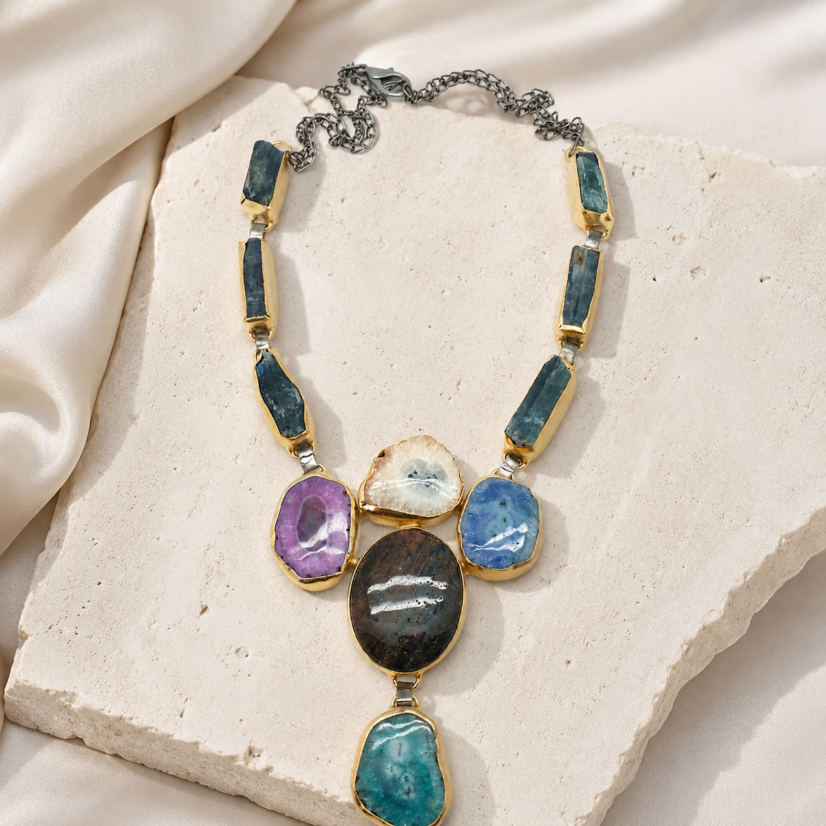 Multi stone agate statement necklace with bold center stones and a gold-tone chain.