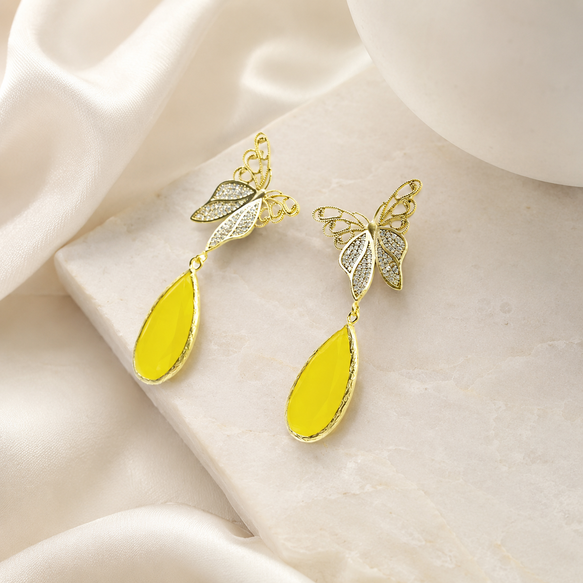 Gold butterfly drop earrings with a teardrop accent styled for a polished look.